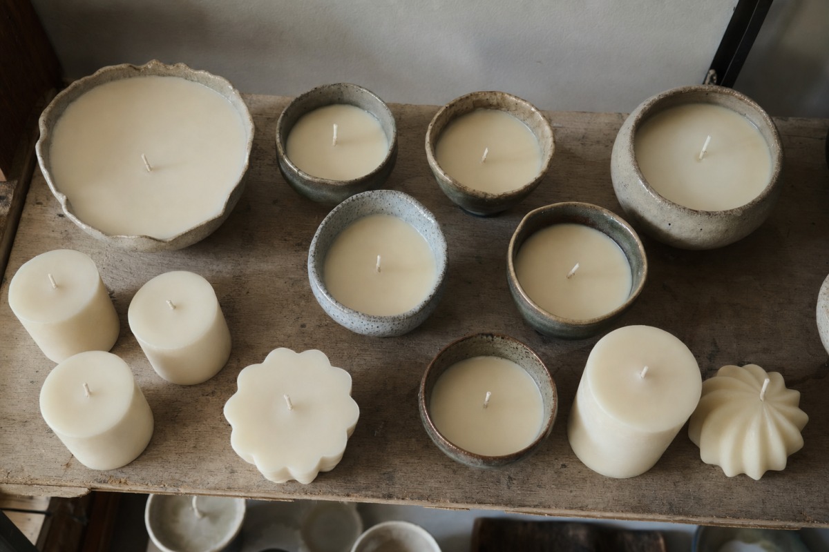 Candele appena colate che si solidificano su una mensola del laboratorio, durante l'attesa