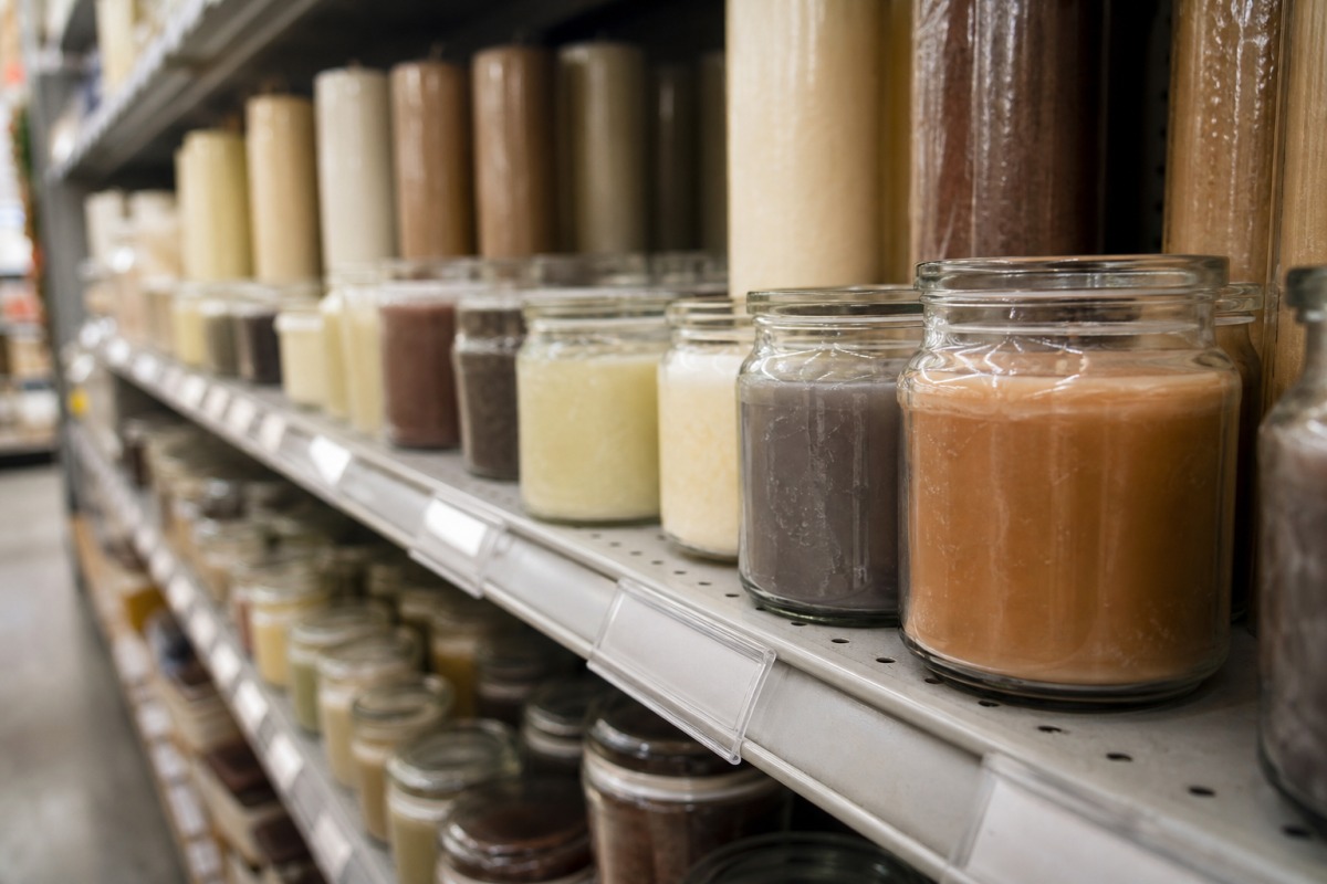 Fila di candele economiche in semplici bicchieri sullo scaffale di un negozio di prodotti per la casa