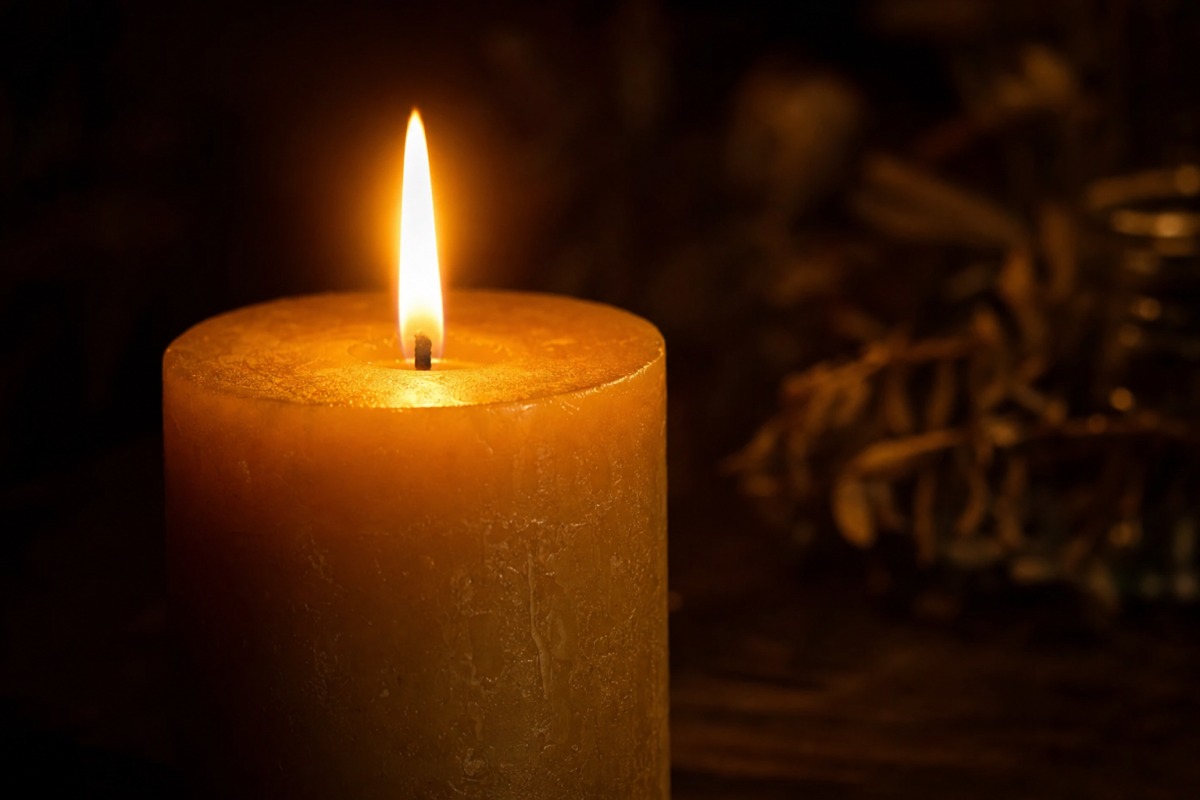 Dettaglio della fiamma uniforme di una candela artigianale accesa
